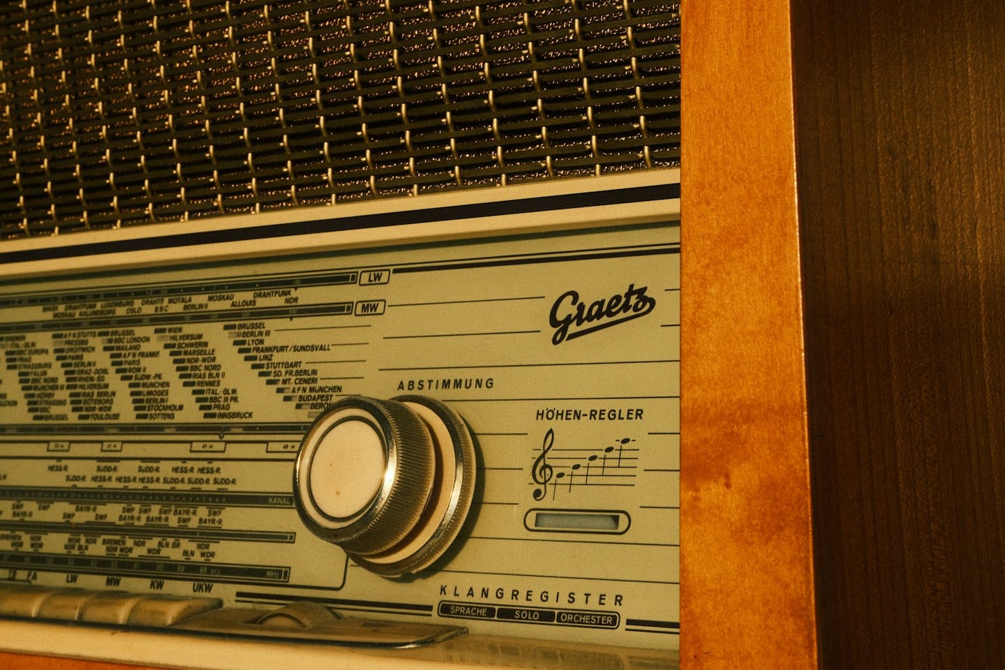 Radio antigua con carcasa de madera y rejilla de altavoz de latón.