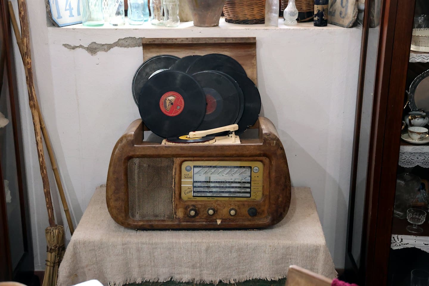 Tocadiscos antiguo con discos de vinilo sobre un mantel de lino.