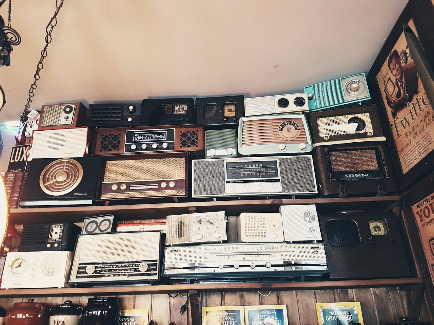 Varios radios antiguos y equipos de audio expuestos en estantes de madera.