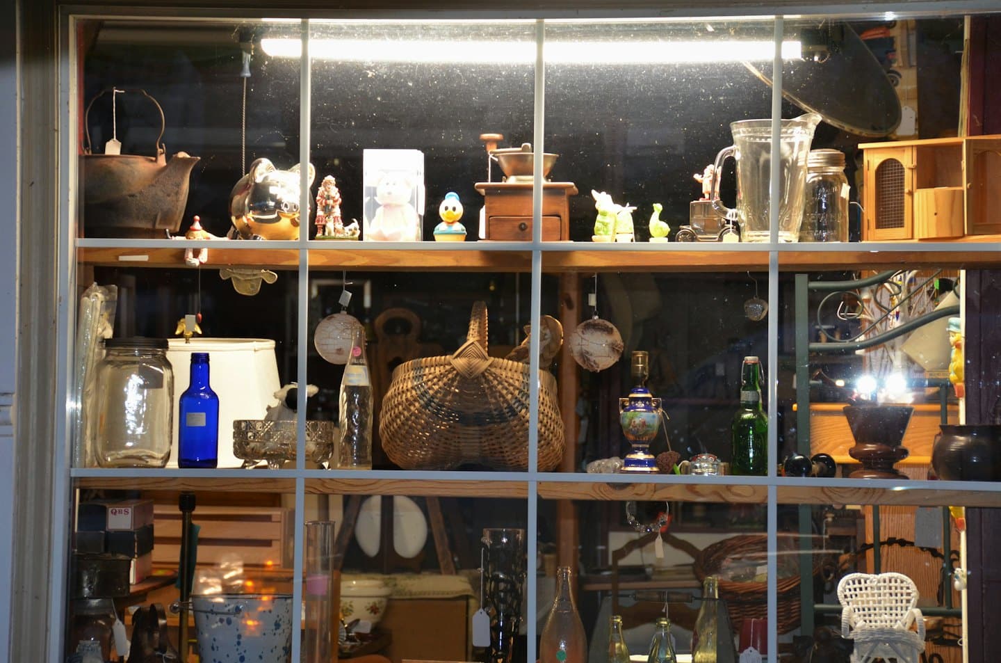 Escaparate de tienda de antigüedades con un surtido de coleccionables vintage.
