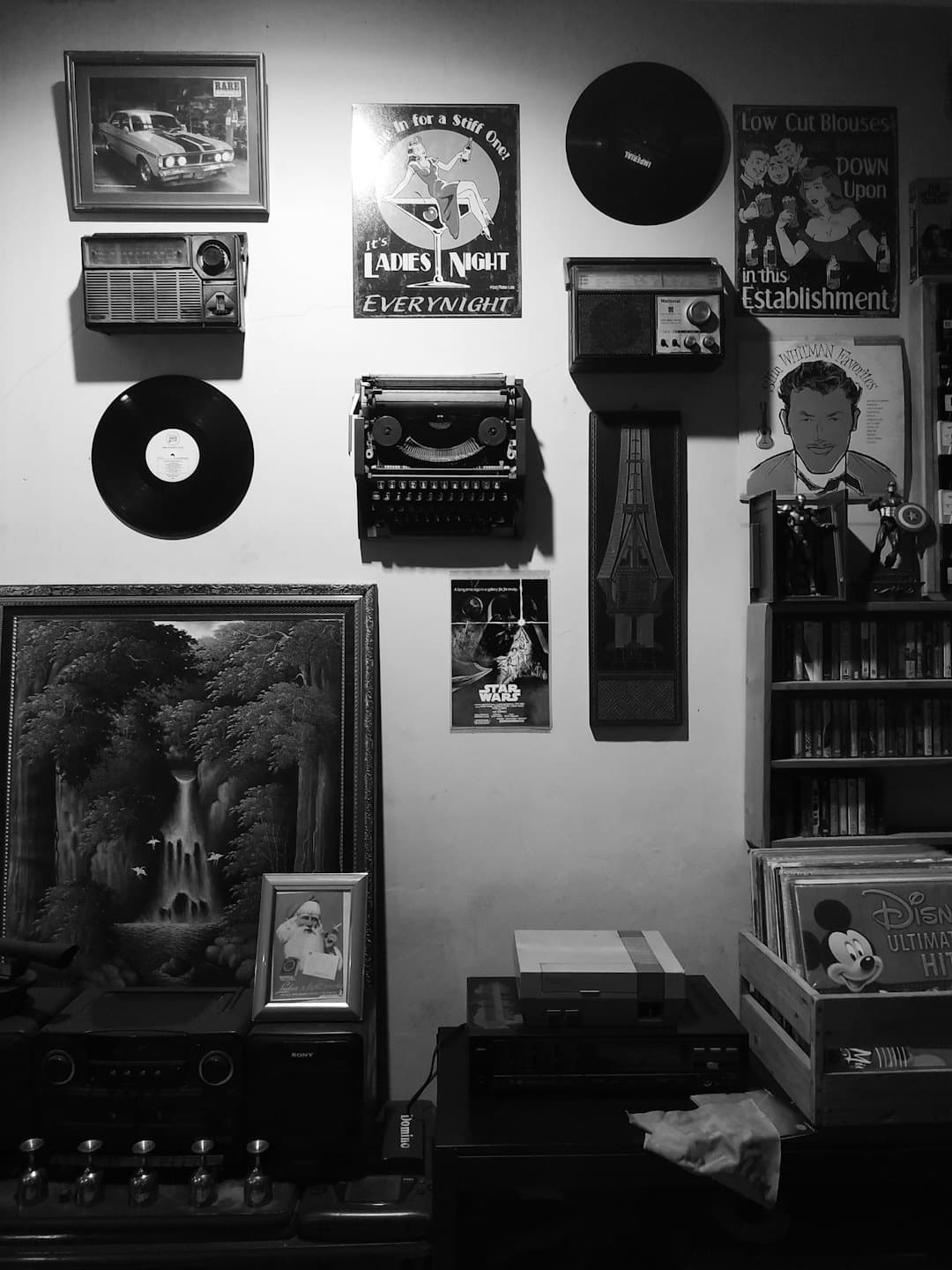 Electrónica vintage y cuadros decoran una pared abarrotada.